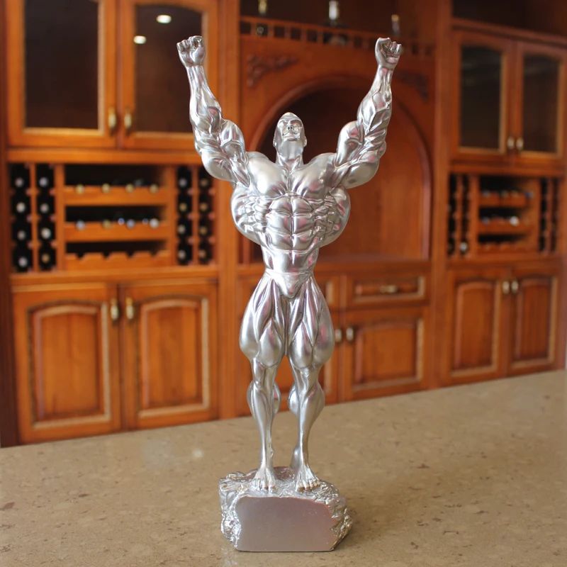 Fitness muscle man sets up bodybuilding sports competition trophies, boxing figures, statues
